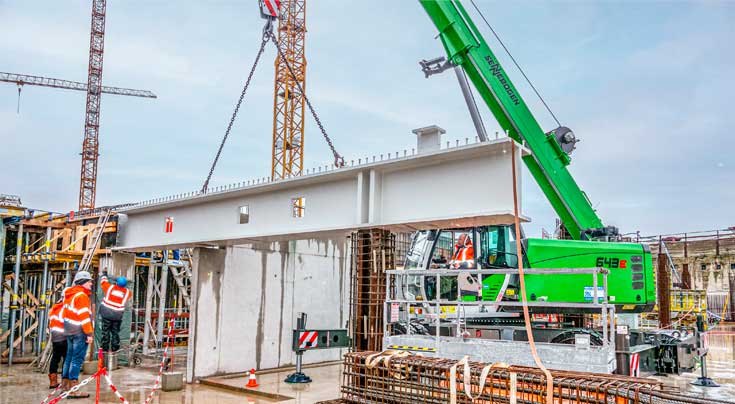 Bei der Platzierung der knapp 14 t schweren Stahlbetonträger ist höchste Präzision gefordert. Fotos: Sennebogen Bei der Platzierung der knapp 14 t schweren Stahlbetonträger ist höchste Präzision gefordert. Fotos: Sennebogen